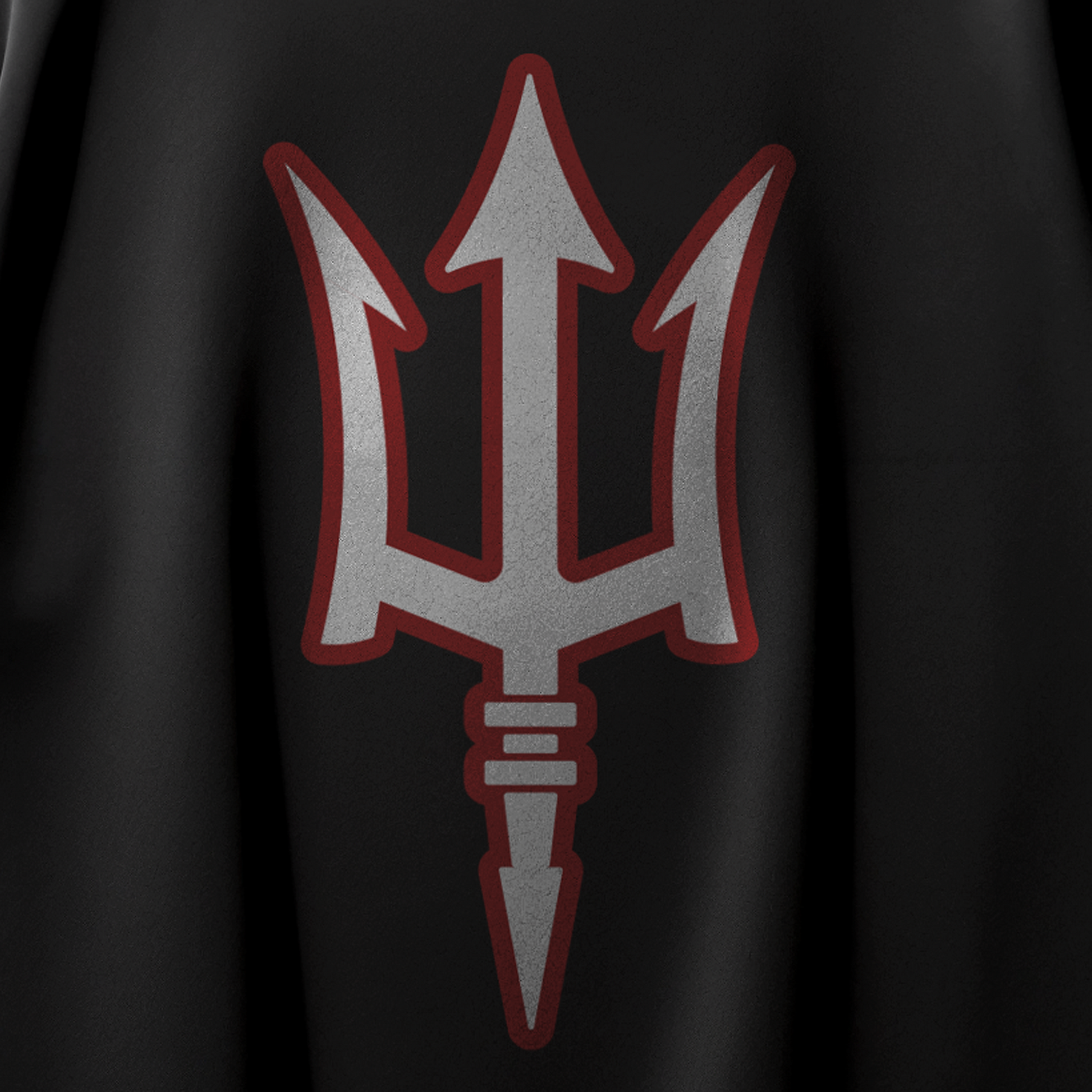 Detalle de la impresión del tridente blanco con el contorno rojo de la Playera TRION DE3P Oversize de algodón negro.